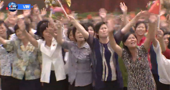 近万名朝鲜民众排列成整齐队伍挥动花束，以口号欢迎习近平到访。（央视）近万名朝鲜民众排列成整齐队伍挥动花束，以口号欢迎习近平到访。（央视）