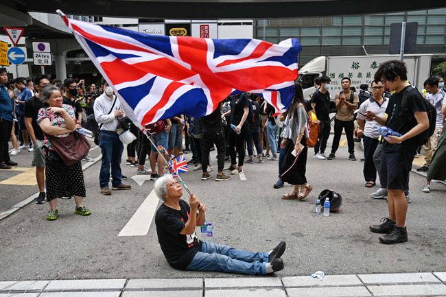 王婆婆孤身一人举着英国国旗。（法新社）