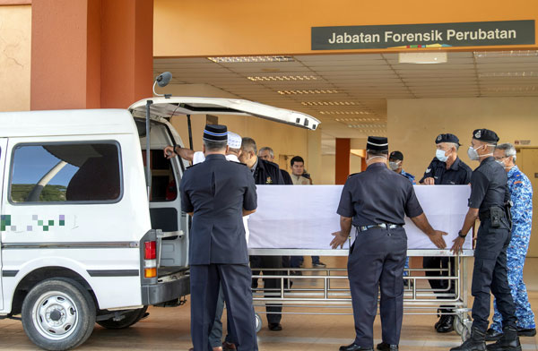 负责人员联合将遗体陆续送上殡仪车。