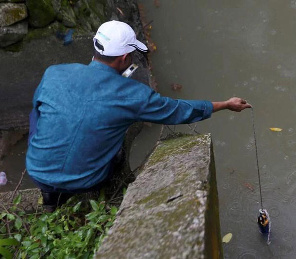 环境局人员抽取巴西古当金金河河水化验。（取自每日新闻网）