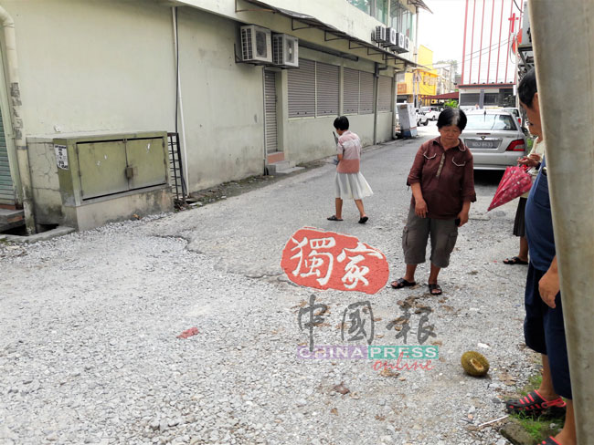邓玉萍（左2）在横巷遇劫，并在碎石地上被拖拉一段距离。