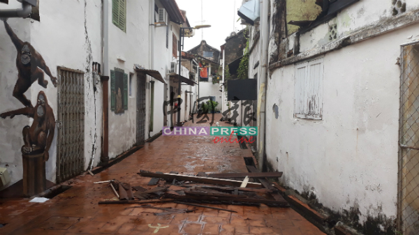 老屋的木板经一场豪雨后掉落在豆腐街壁画走廊。