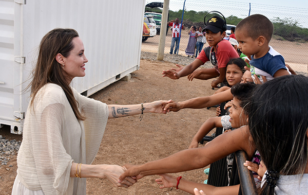 安芝莲娜祖莉在迈考联合国难民营和委内瑞拉孩子们握手。（欧新社）