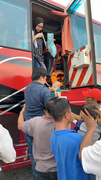 巴士车乘客在路过者协助下，从紧急逃生门逃出。