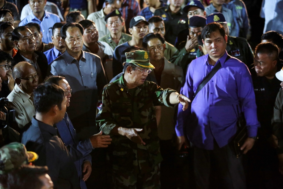 身穿军装的柬埔寨首相洪森（中），周一凌晨到建筑物倒塌现场视察。（法新社）