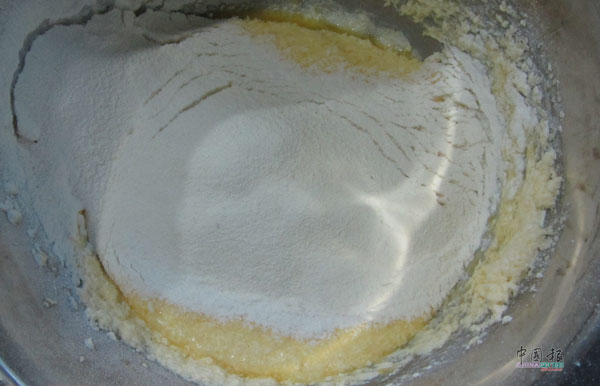 4）面粉和泡打粉过筛至牛油糊，拌均匀即可。