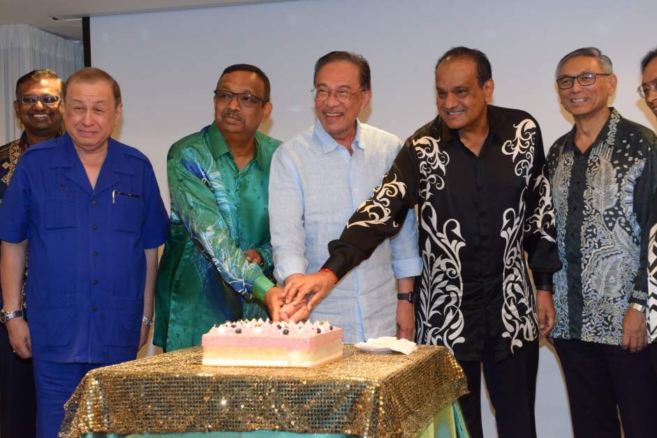 安华（中）在马来西亚─印度商业理事会开斋晚宴切蛋糕，右2为古纳西淡巴兰。