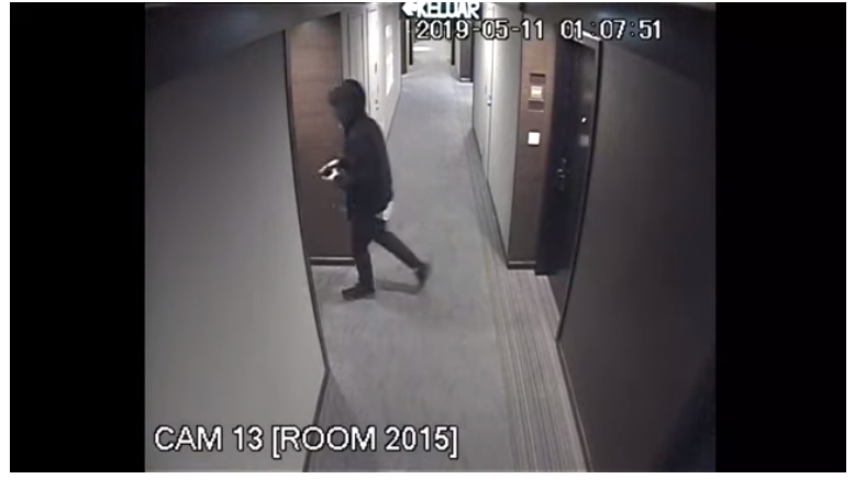 有一名披着外套，遮着头部的男子被拍到进入一个房间。