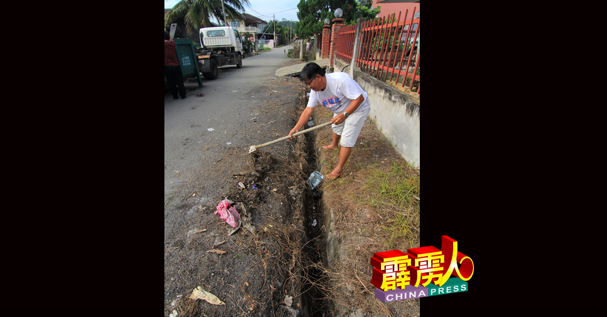村民钟东明响应“利民加地新村大扫除”活动，清除沟渠的垃圾。