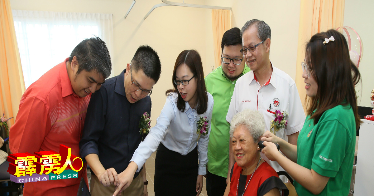 李文材（右2起）与张思源、崔慈恩、黄家和及吴国锋，细心了解听力学家李慧娴（右），为公众检查听觉的过程。