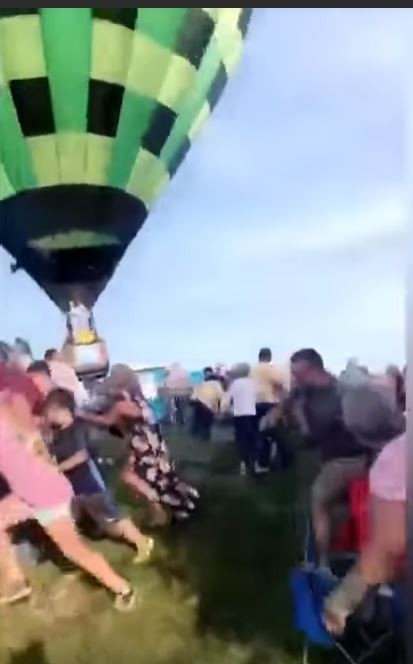 热气球朝地面人群袭来，民众纷纷惊慌逃离。
