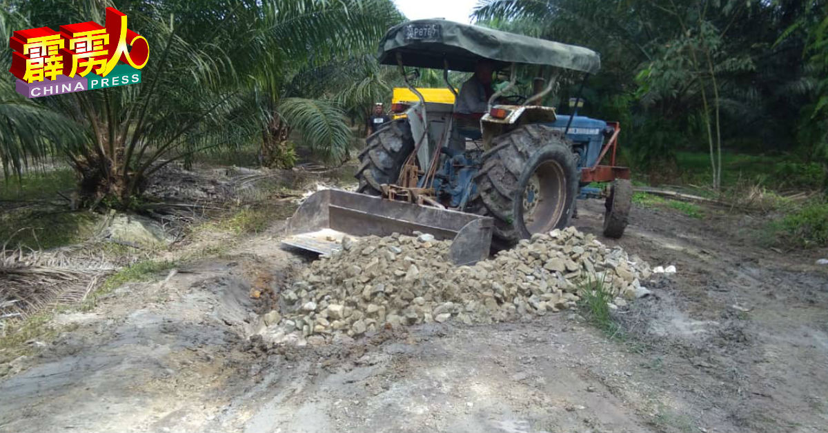 工作人员维修爱大华拉惹依淡通往哲仁新村的失修道路。