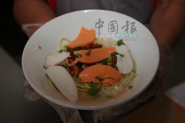 人们在干捞鱼饺面中加入红色鱼饼，使得鱼饺面更有色彩与美味。