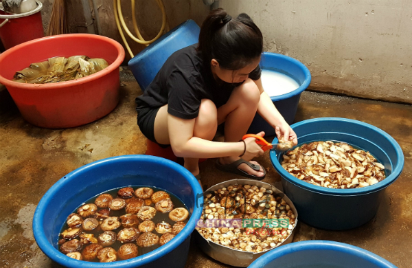 年轻一代在端午节前回家帮忙制作粽子，包括处理花菇等。