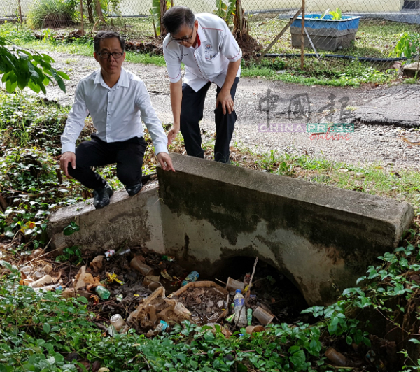 刘志良（左起）及陈劲源巡视堆满垃圾的沟渠。