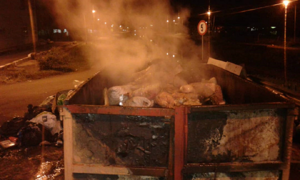 拾荒者在凌晨时分，纵火焚烧垃圾槽。