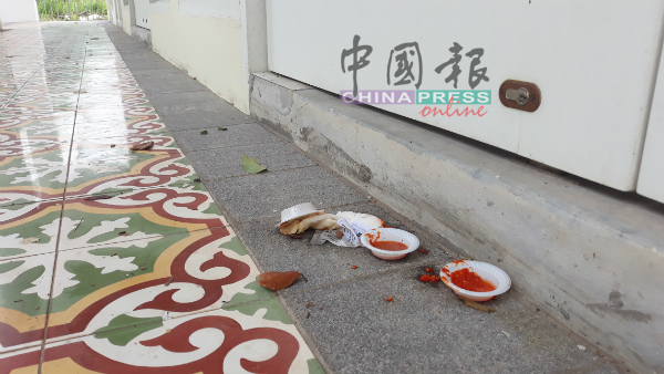 小吃下肚后，民众将盛装辣椒酱的塑料碟随手弃在店铺走廊。