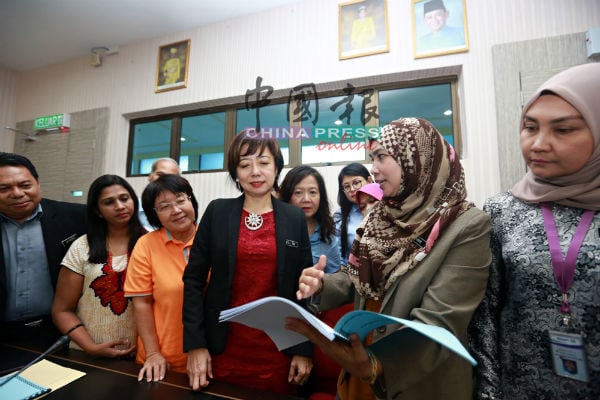 鲁詹娜（右2）向陈丽群及其他协调员讲解“卓越妇女授权中心”（PH GEM）推行的各项提升妇女知识及竞争能力的活动或就业课程的计划书。