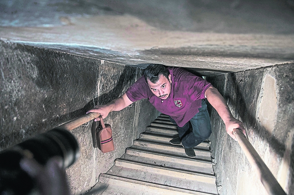 一名男子进入弯曲金字塔，在狭窄的隧道拾级而上。（欧新社）