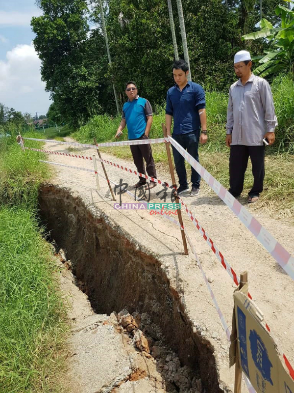 郭子毅（中）在接获河边道路发生土崩的事故后，与乡理会成员到场巡视。