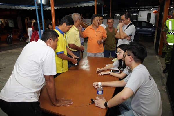 森华青成员在辩论开始前，设有柜台协助村民检查选民身分。