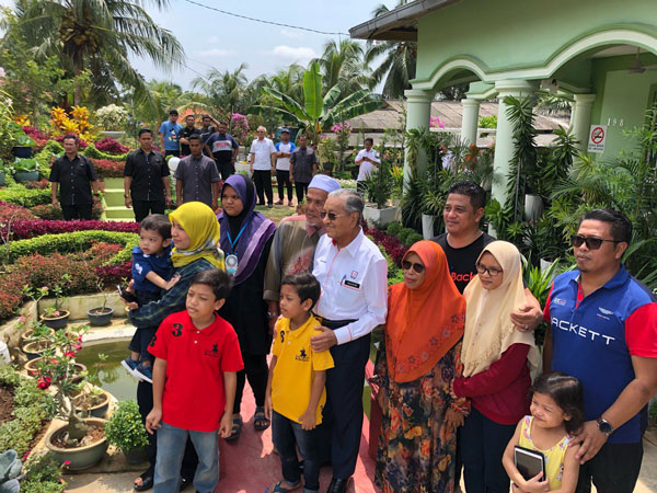 马哈迪（右5）也亲自拜访得奖者的住家，并与得奖者一家合影留念。