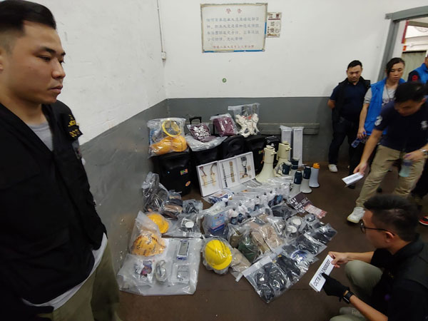 警方展示检获的攻击物武器、头盔、衣物、炼制炸药的器具。（美联社）