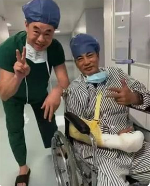任达华在中山医院接受手术后，坐在轮椅上和医护人员合照。