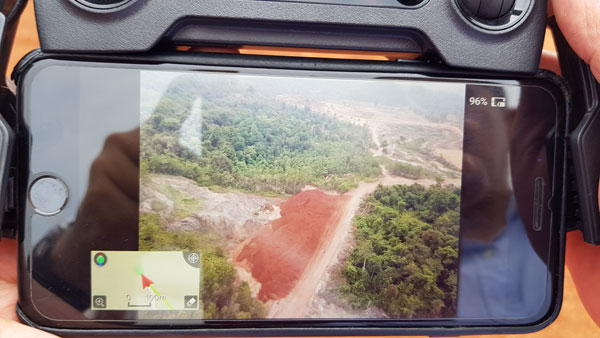 地主展示无人机拍下堆积的矿泥堆。