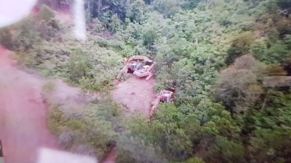 无人机拍下多辆泊放山林内的神手，周遭不见有人作业。