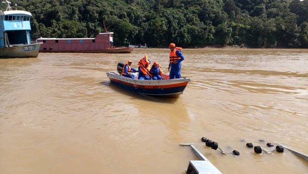 搜寻队乘船在河流寻找失踪的华裔驾驶员。