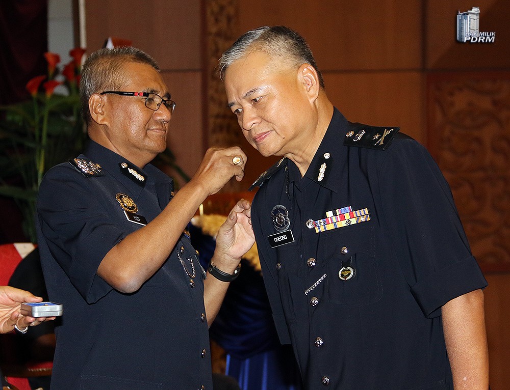 拿督钟勤国（右）数年前，获时任警察总长丹斯里弗兹颁发表扬勋章。
