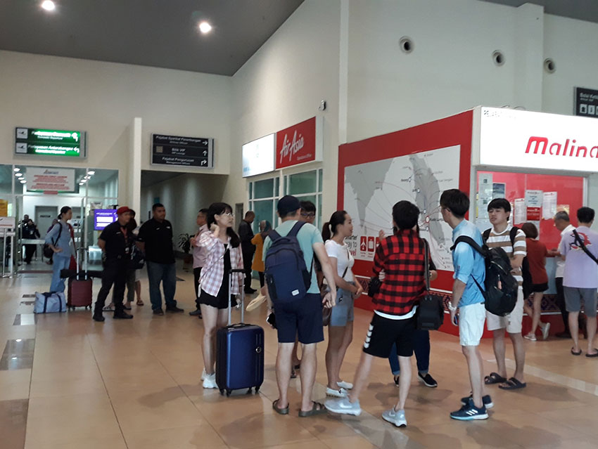 大批乘客集聚在亚航客服中心外了解最新详情。