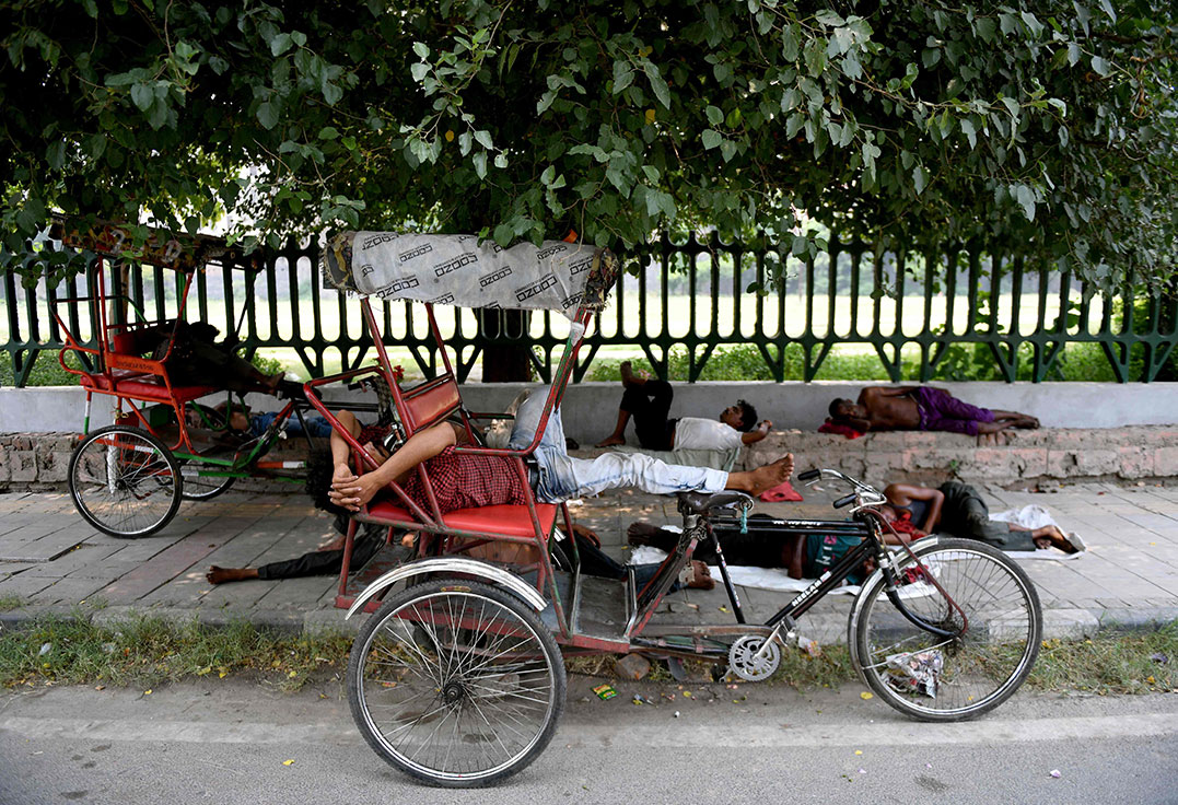 周二在新德里，民众热到直接躺在地上睡觉。（法新社）