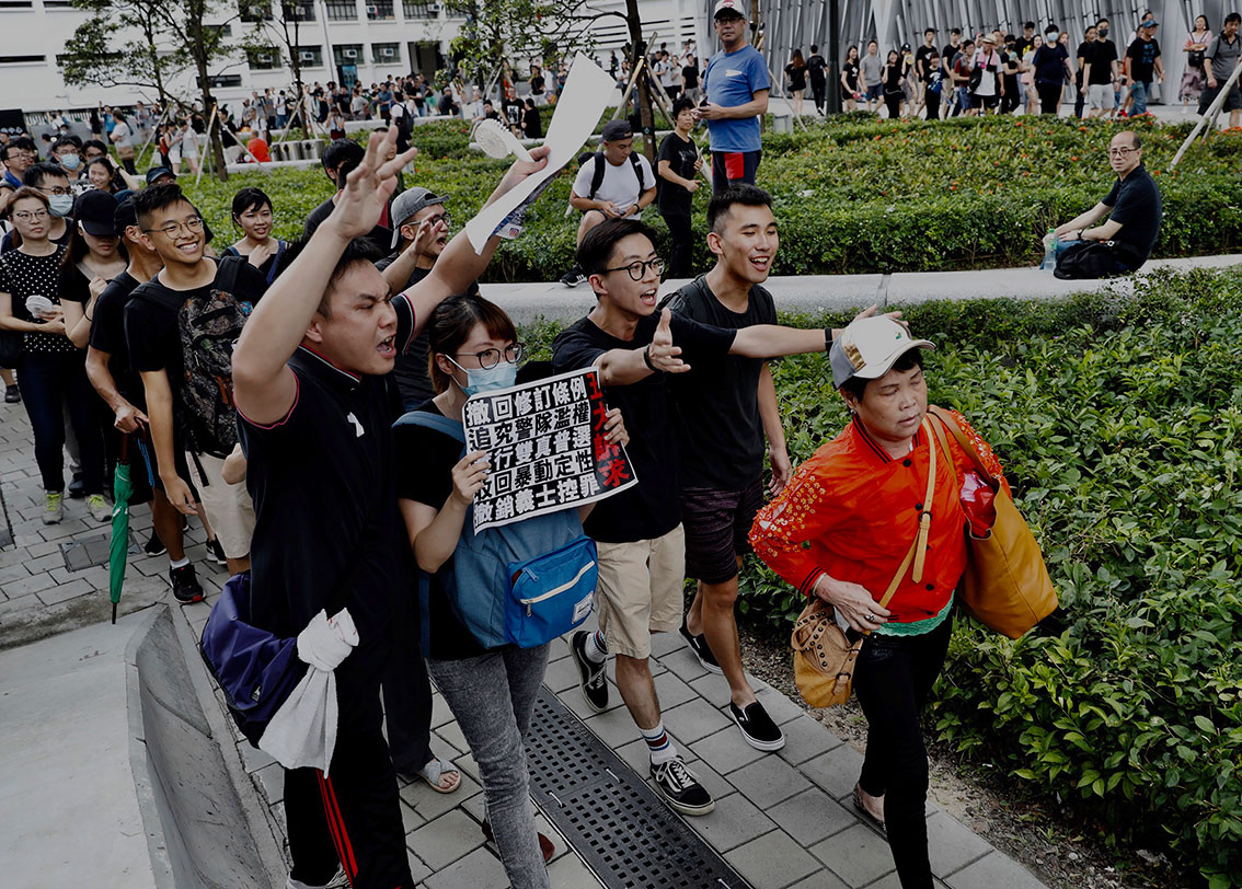 示威者走在一名中国游客后面。