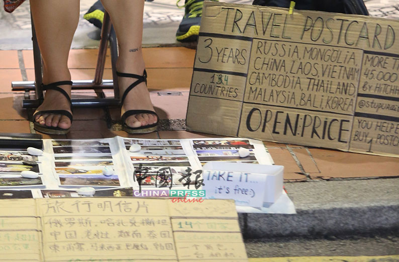 非法摆摊的俄罗斯背包客以中英文书写，向民众筹集旅费。
