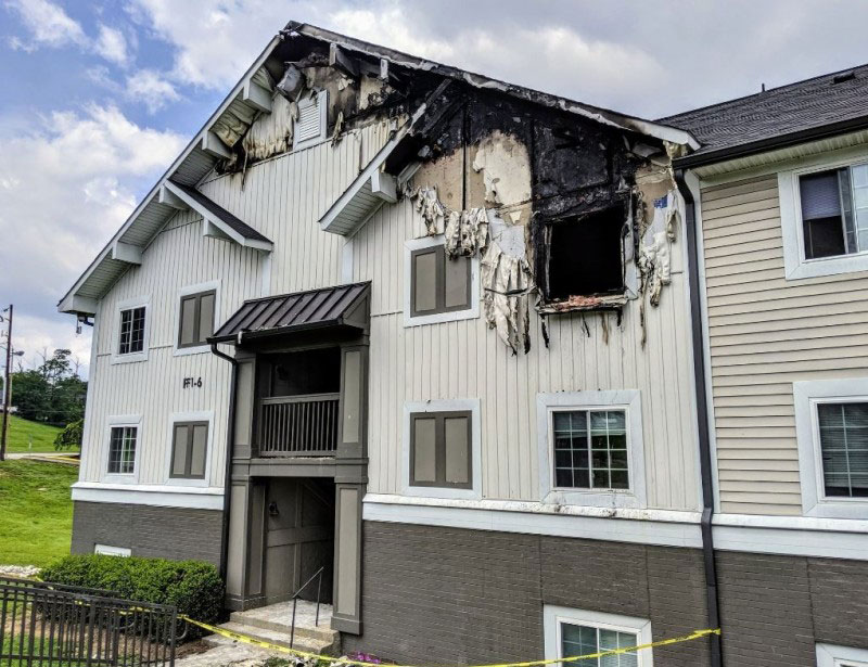 发生火灾的屋子，屋顶和楼上窗户遭火苗吞噬，一片焦黑。警方在屋子周围拉起警戒线封锁。