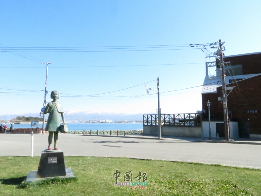 入住的SHARE HOTELS HakoBA Hakodate面向海港，小女孩铜像、蓝天、白云和草地，形成一幅美不胜收的风景。