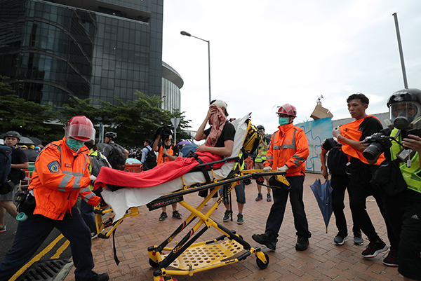 在香港立法院附近，一名示威者头部受伤，被抬上担架准备送院治疗。（欧新社）