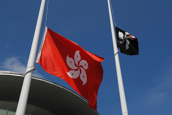示威者阻扰升旗礼，把原本的中国国旗换成黑色的香港金紫荆旗（右）。（美联社）