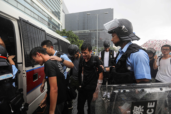 一些示威者被警员押上警车。（法新社）