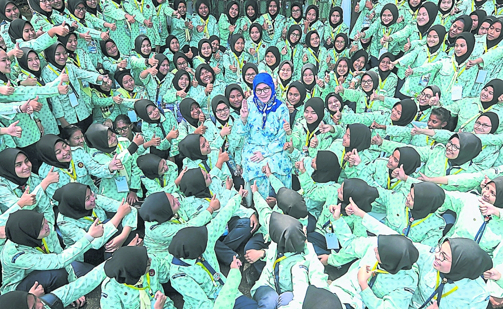 东姑阿兹札（中）举起三指敬礼手势，表现国家元首后是女童军的一分子。