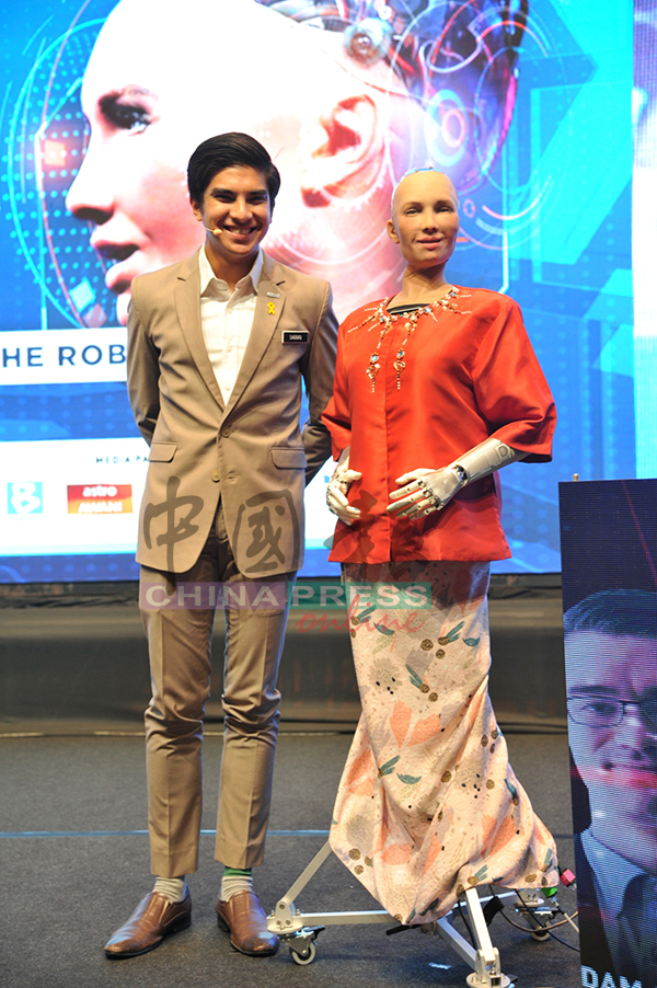 赛沙迪（左）与机器人索菲亚（Sofia）合影。