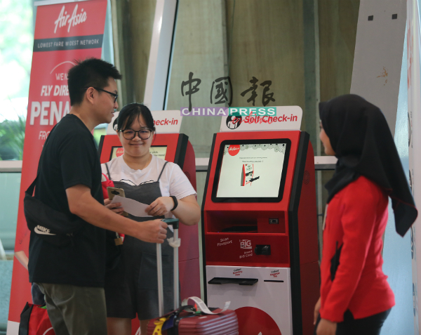 乘客使用自动登机柜台办理登机手续。