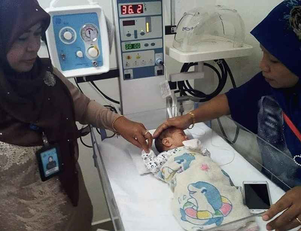 警方把弃婴带到医院做身体检查。
