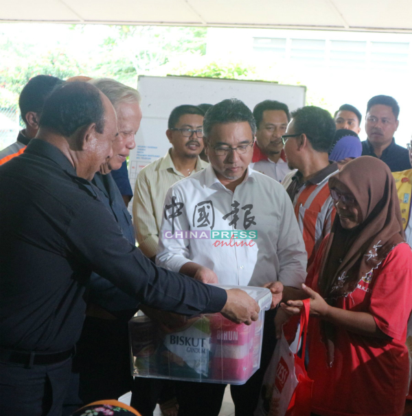 甲州元首（前左2起）与甲首长颁发物资给水灾灾民。
