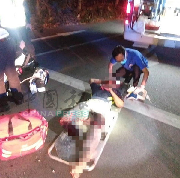 医务人员准备将其中1男伤者抬上救护车送院。