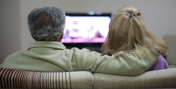 若在家长时间坐着不动只看电视，可能增加心脏病的风险。（示意图）
