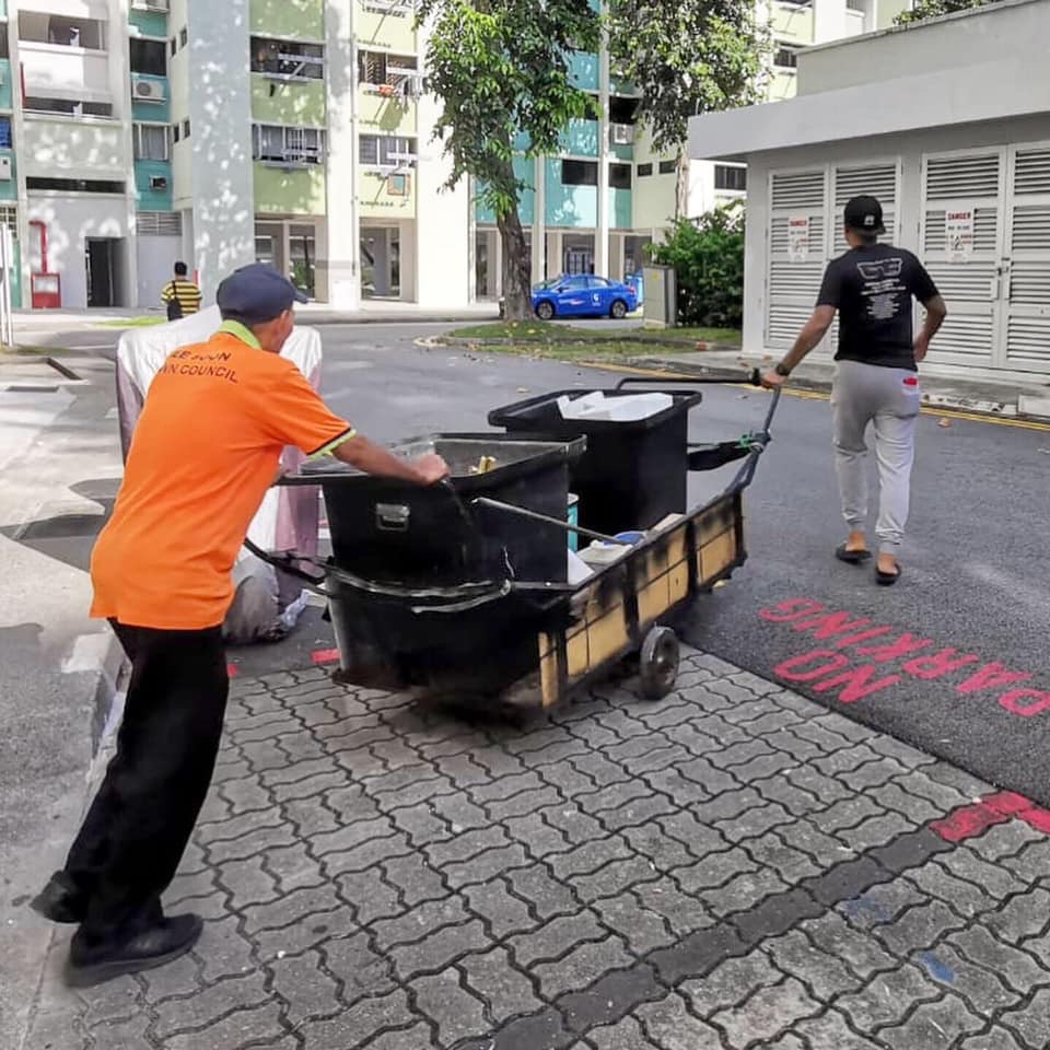 沙里祖马安（右）帮忙手推垃圾推车。
