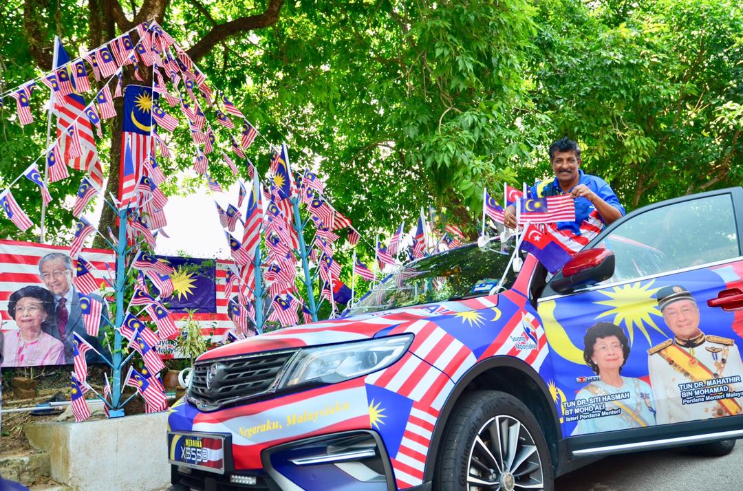 甘达班以首相夫妇肖像装饰新购的轿车，并准备开往布城参加国庆日庆典与首相见面。